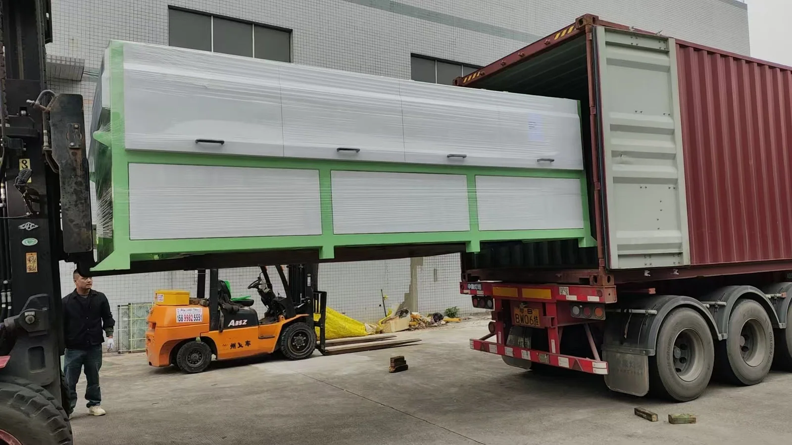 A complete line section is lifted towards the container.